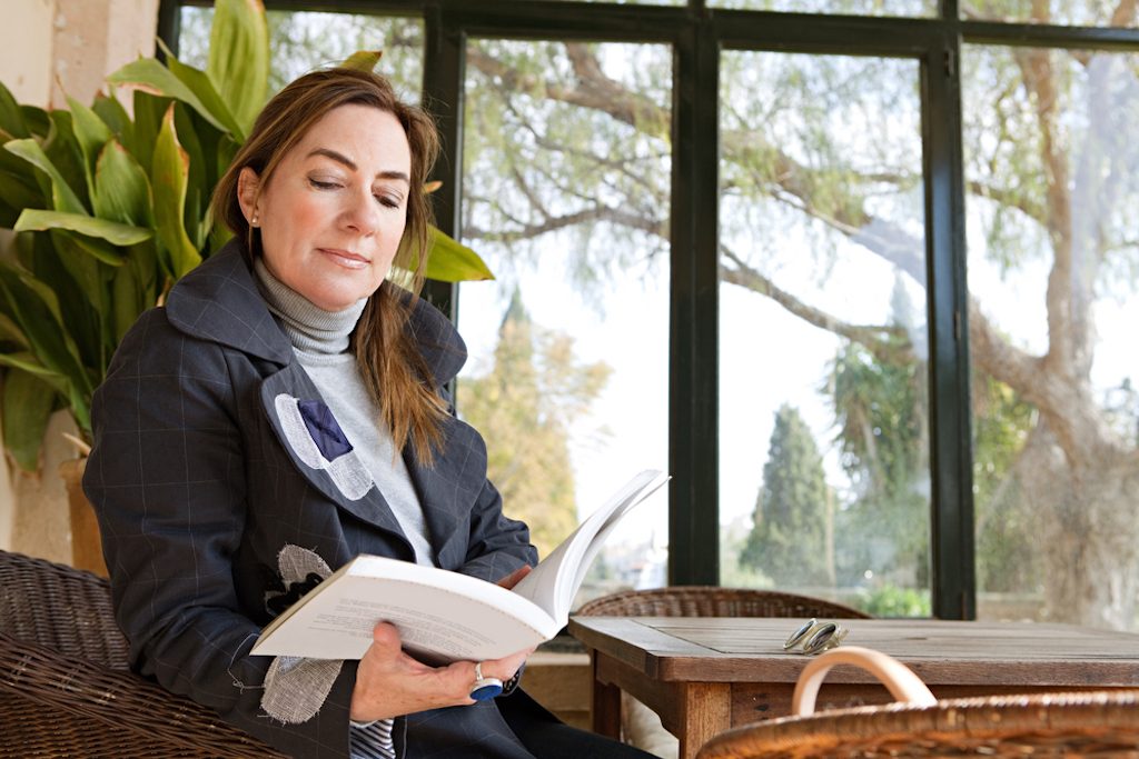 woman sitting reading in a too hot conservatory