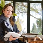 how to keep your conservatory warm showing a woman reading book